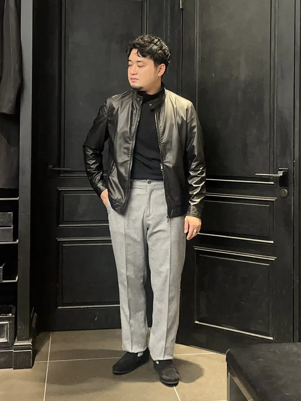 EMMETI(エンメティ) PARIGOT別注JURI 黒レザージャケットにライトグレーのスラックスとスエードローファーを合わせたメンズコーデ
